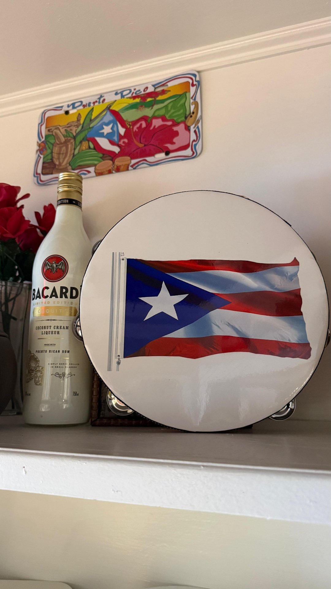 Puerto Rican flag tambourine and Bacardi Coquito bottle on a shelf at Caribe