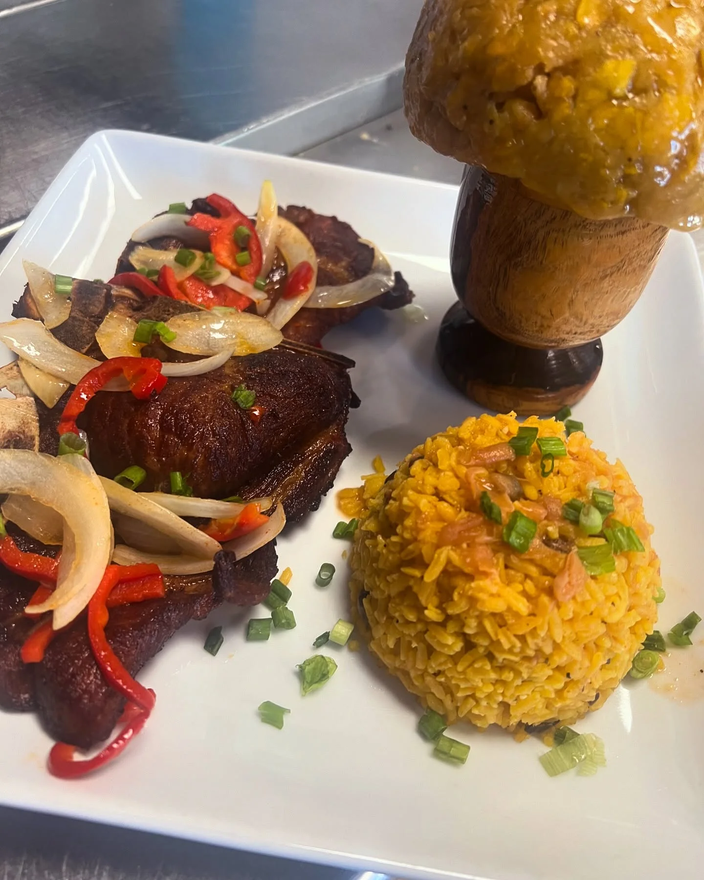 Chuletas (pork chops) with peppers, mofongo, and yellow rice at Caribe