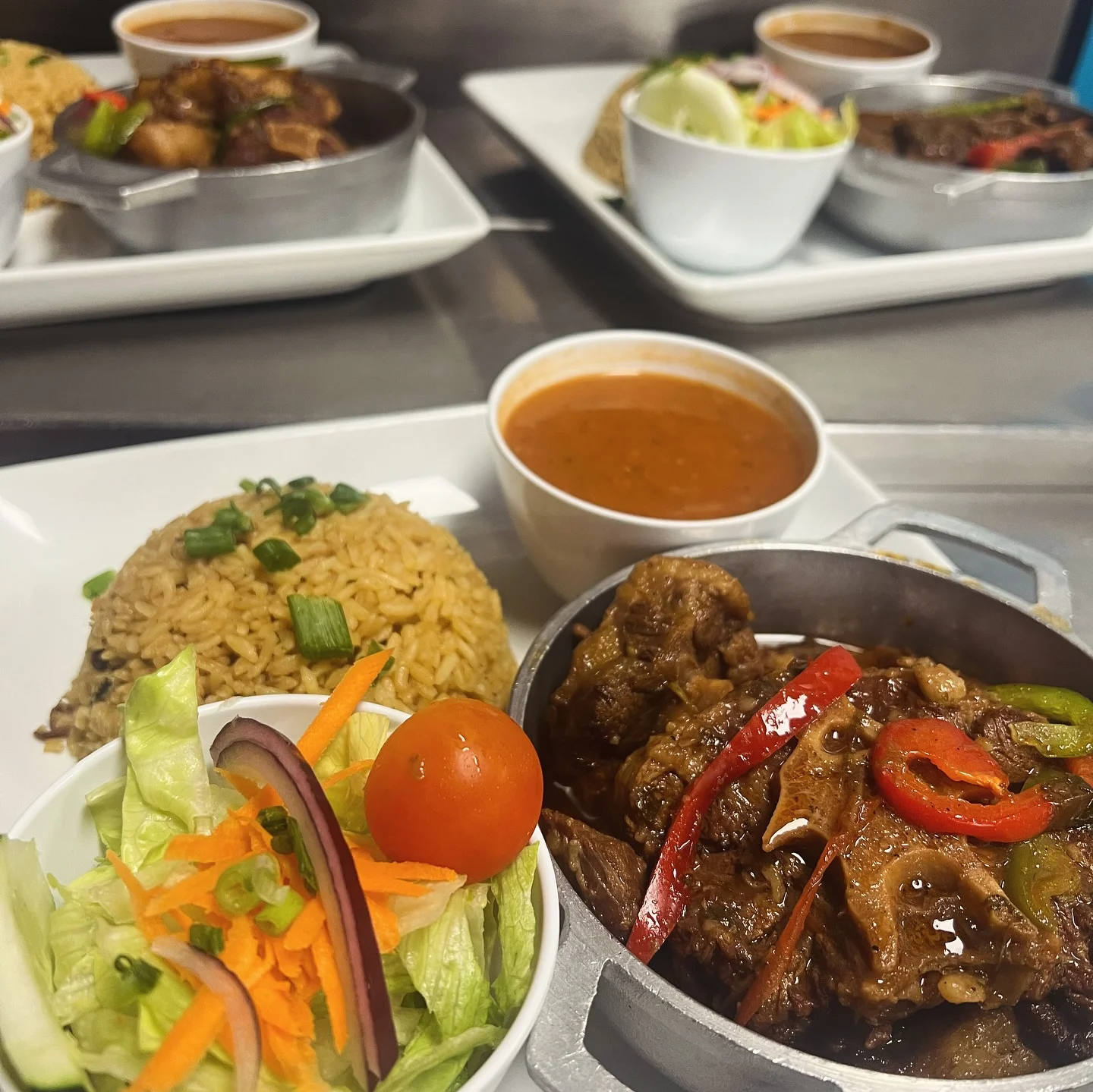 Stewed oxtails with rice, beans, and salad at Caribe