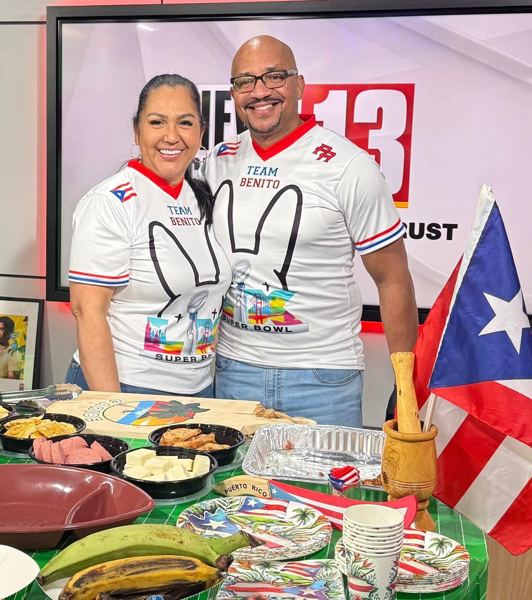 Maggie and Fermin Fabian on WNYT News Channel 13 wearing Team Benito Bad Bunny Super Bowl jerseys with Caribe Puerto Rican spread