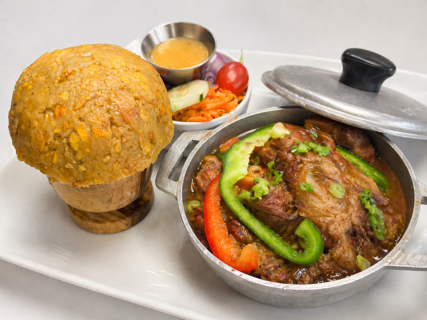 Stewed oxtails with peppers in a Caribbean pot served with a tall mofongo at Caribe
